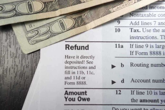 shutterstock_173624585.jpg Close-up of tax refund form with cash on a wooden surface