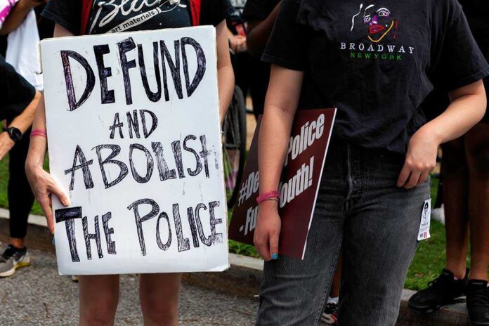 Protesters holding signs advocating to defund and abolish the police