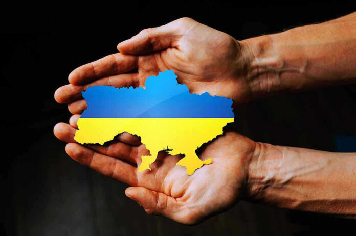 2129047880 Hands holding Ukraine map with flag design.