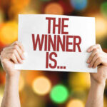 Major Trump WIN: Legal VICTORY Hands holding a sign reading The Winner Is...