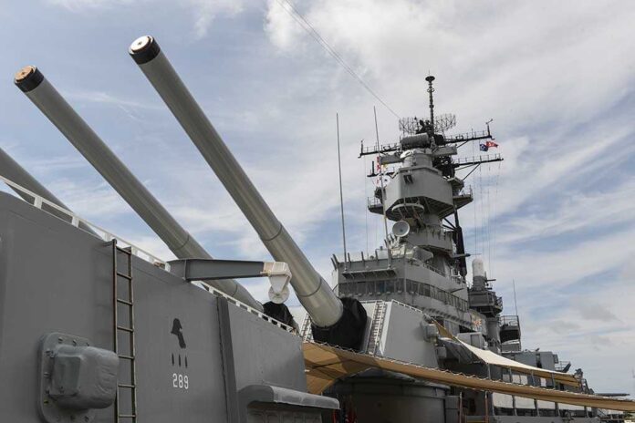 Close-up of a battleships naval guns and superstructure against a cloudy sky
