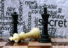 Chess pieces with secretive background text pattern
