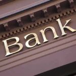 Banking Privacy Laws BACKFIRE — Customers Trapped Bank sign on building facade.
