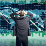 Person in front of falling stock market graph.
