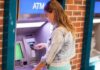 Young woman using an ATM in an urban environment