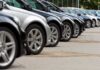 A row of parked black and silver cars in a dealership