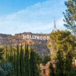 Beloved Star’s Sudden Death Shocks Hollywood Hollywood sign on hill surrounded by trees and buildings.