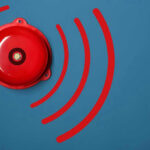 Red alarm bell on a blue background.