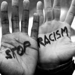 Two hands with Stop Racism written on them.