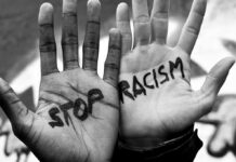 Racism Accusation Erupts Over Newsom Remark Two hands with Stop Racism written on them.