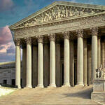Building with columns and statues in front of entrance.