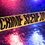 Thugs Storm Temple—DAD’S Body Dumped Lake Yellow crime scene tape with police lights in background.