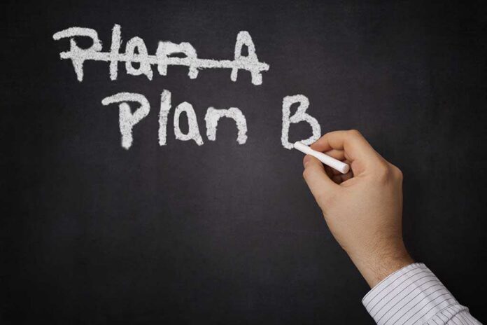 A hand writing Plan B on a chalkboard with Plan A crossed out