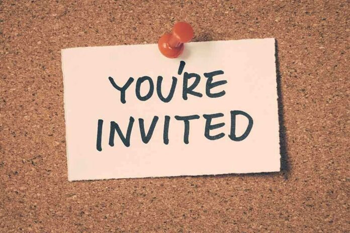 A note pinned to a corkboard that says 'YOU'RE INVITED'