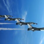 F-35 INSTRUCTOR ARRESTED — Shocking Treachery Four military jets flying in formation against a blue sky, leaving smoke trails