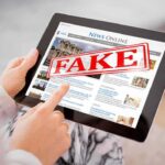 Fake Prince CONTROLLED Government—For 10 YEARS Person holding a tablet displaying a news website with a 'FAKE' stamp