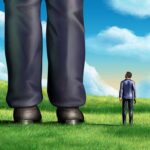 A small person looking up at a giant figure in a grassy field under a blue sky