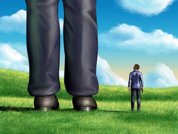 shutterstock_74454625.jpg A small person looking up at a giant figure in a grassy field under a blue sky