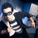 Bystander Rams Robbers’ Car—Heist FOILED A masked thief in a striped shirt holding a bag while emerging from a bank vault