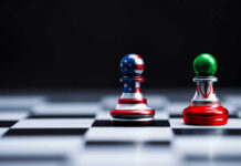 Chess pieces with USA and Iran flags on board.