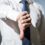 Person giving a thumbs down gesture.