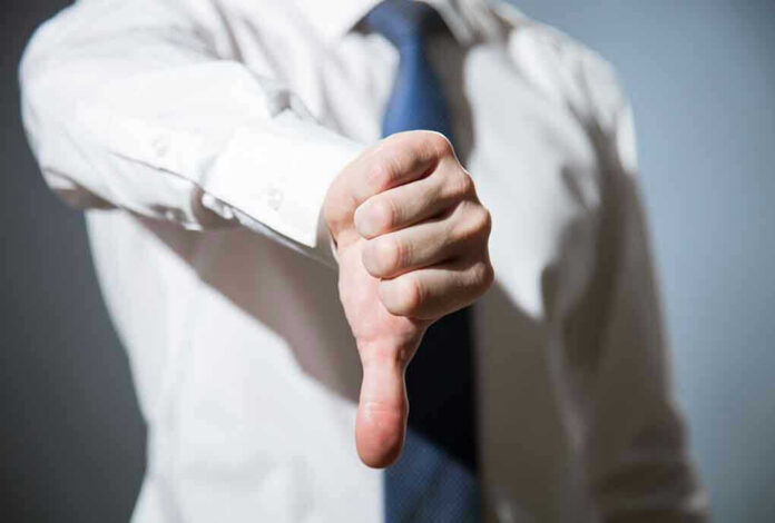 Person giving a thumbs down gesture.