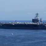 Missile Barrage SLAMS U.S Carrier! A large aircraft carrier sailing in the ocean