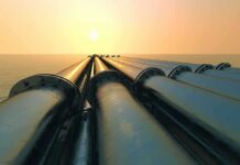 Oil Panic: 400 Million-Barrel Dump Industrial pipes extending towards the horizon over water during sunset