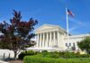 Supreme Court building with American flag and surrounding greenery