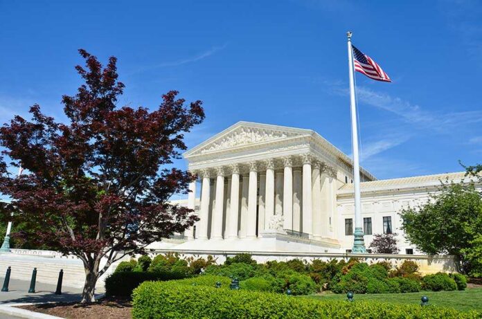 shutterstock_141389569.jpg Supreme Court building with American flag and surrounding greenery