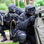 A tactical team in black gear preparing for an operation