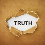 A piece of torn paper revealing the word TRUTH underneath