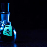 China’s Cyanide ATTACK on American Ally EXPOSED Dark bottle with skull-and-crossbones label on table.