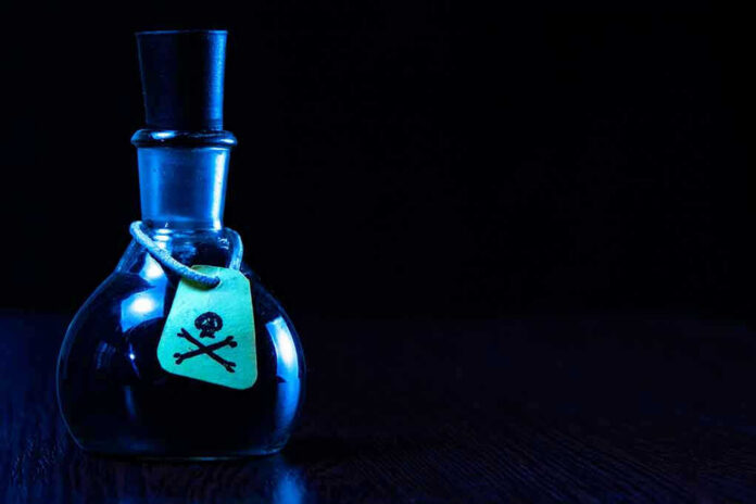 1946359798 Dark bottle with skull-and-crossbones label on table.