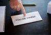 Envelope with YOURE FIRED and pointing finger.