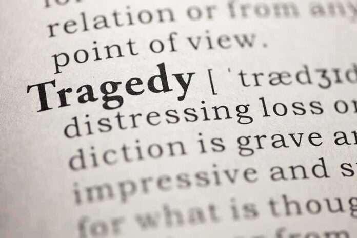 Close-up of a dictionary page showing the definition of 'tragedy'