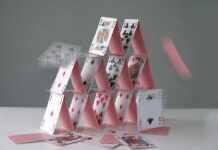 A house of cards collapsing with some cards in motion
