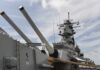 Close-up of a battleships naval guns and superstructure against a cloudy sky