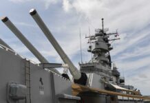 Close-up of a battleships naval guns and superstructure against a cloudy sky