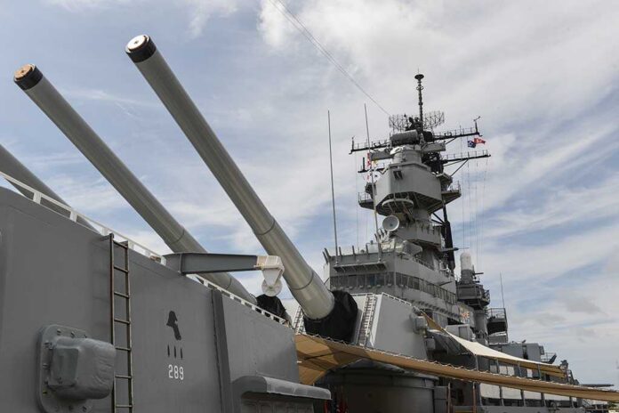 Close-up of a battleships naval guns and superstructure against a cloudy sky
