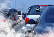 Traffic jam with cars emitting exhaust fumes on a city road
