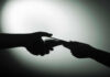 UNCORROBORATED Hush-Money ACCUSATION Targets Rep. Massie Silhouette of hands exchanging money in dim light.