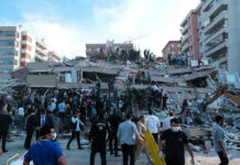 Deadly Drone Strike Rocks Russian OIL HUB People at a collapsed building after an earthquake.