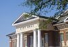 Shock Exit — Mayor Quits After Re-election Exterior view of a city hall building with columns and a clear blue sky