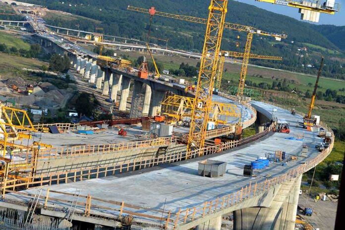 shutterstock_37230340 Construction of a large bridge with cranes and machinery in operation
