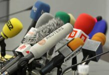 Candidate Makes SHOCKING Internment Camp Proposal A collection of various microphones arranged for a press conference