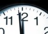 Close-up of a clock showing the time just before noon