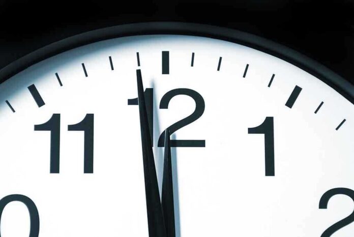 Close-up of a clock showing the time just before noon