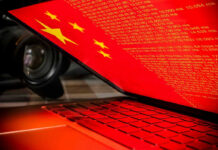 Beijing’s Bot Army Deploys Laptop screen displaying Chinese flag and code.