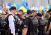 Police officers gathered near a crowd with flags.